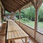 Terrasse en bois de la Zanni Compagnie à Toulouse avec grandes tables.